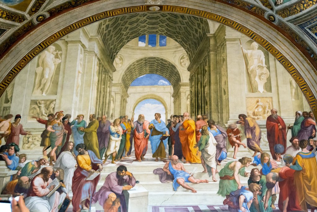 A detailed fresco depicting the School of Athens, featuring prominent philosophers and scholars in an architectural setting with arches and statues.